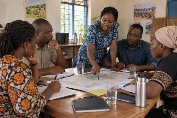 An NGO team planning field work around a map